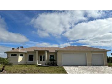 Charming single-story home featuring a two-car garage, light yellow paint, and an expansive front yard with clear blue skies at 6372 Grove Blvd, Punta Gorda, FL 33982
