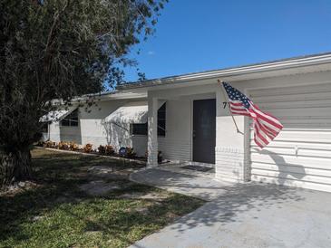 Charming single-story home featuring a well-manicured lawn, crisp white paint, and an American flag at 710 Aqui Esta Dr, Punta Gorda, FL 33950