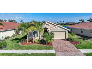 Charming single-Gathering home featuring a brick driveway and a well-manicured lawn with tropical landscaping at 7346 Talon Bay Dr, North Port, FL 34287