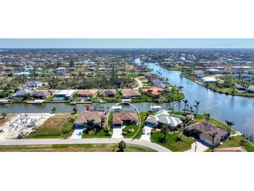 Aerial view of waterfront home with private dock and lush landscaping at 15706 Viscount Cir, Port Charlotte, FL 33981