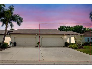 Exterior view of a charming villa with a two-car garage and well-manicured landscaping at 523 Foxwood Blvd, Englewood, FL 34223