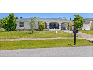 Ranch style home with carport and nicely landscaped lawn at 6064 Deming Ave, North Port, FL 34287