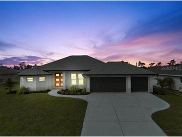 Beautiful modern home with three-car garage and landscaped lawn at 256 Mariner Ln, Rotonda West, FL 33947