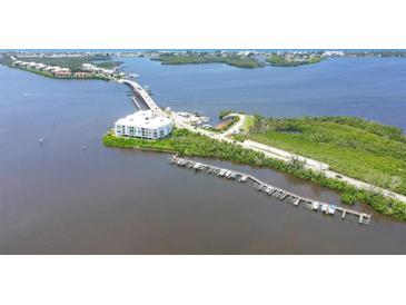 Aerial view of waterfront property with boat slips and a modern building at 1375 Beach Rd # 210, Englewood, FL 34223