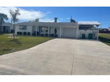 Ranch style home with large driveway and mature landscaping at 105 Crestview Dr, Englewood, FL 34223