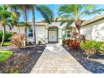 Charming single-story home with a well-manicured lawn, lovely landscaping, and a welcoming front entrance at 65 Par View Ter, Rotonda West, FL 33947