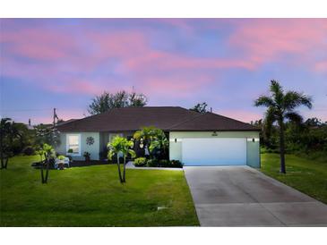 One-story home with a two-car garage and a lush lawn at 13515 Keystone Blvd, Port Charlotte, FL 33981