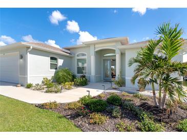 Charming single-story home featuring manicured landscaping, a light blue exterior, and a welcoming front entryway at 180 Rotonda N Blvd, Rotonda West, FL 33947