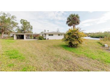 Ranch style home with carport and spacious yard, located on a canal at 446 Court St, Englewood, FL 34223