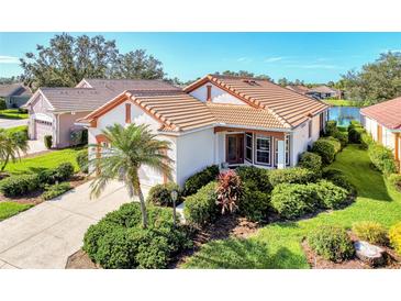 Single-story home with a tile roof, two-car garage, and lush landscaping at 3238 Osprey Ln, Port Charlotte, FL 33953