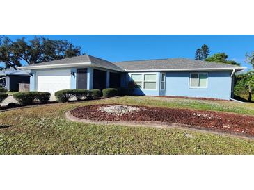 Ranch-style home with a landscaped yard and attached garage at 1329 Sheehan Blvd, Port Charlotte, FL 33952