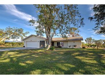 Single-story house with a large yard and mature trees at 1951 Greenlawn Dr, Englewood, FL 34223