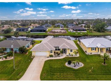 Aerial view of a single-Gathering home with a canal-front lot and lush landscaping at 233 Marker Rd, Rotonda West, FL 33947