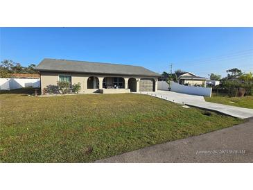 Single-story home with a driveway and landscaped lawn at 23046 Foote Ave, Port Charlotte, FL 33952