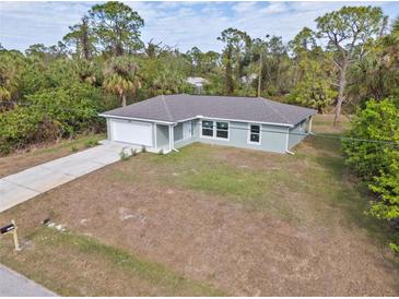 New construction home with a large yard and driveway at 2462 Ensenada Ln, North Port, FL 34286