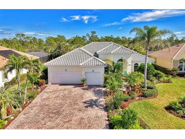 Attractive single-story home with tile roof, paver driveway, and lush landscaping at 2864 Mill Creek Rd, Port Charlotte, FL 33953