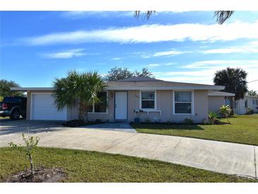 Single-story home with attached garage, driveway, and landscaping at 4064 Harbor Blvd, Port Charlotte, FL 33952