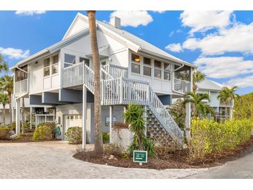 Charming elevated beach house with a gray metal roof, and a wrap around porch at 5000 Gasparilla Rd # 48, Boca Grande, FL 33921