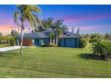 Stunning curb appeal with a modern design, lush lawn, and solar panels at 7510 Kenway St, Englewood, FL 34224