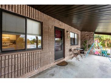 Inviting porch with seating and a partial kitchen view at 9000 Griggs Rd # G, Englewood, FL 34224