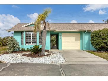 Charming teal home with a one-car garage and nicely landscaped front yard at 255 Boundary Blvd # 105, Rotonda West, FL 33947