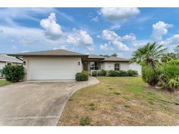Single-story house with attached garage, landscaping, and a driveway at 11091 Corrigan Ave, Englewood, FL 34224