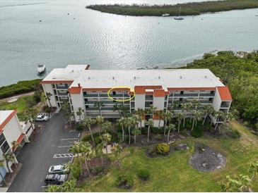 Aerial view of waterfront condo building showcasing its location and water access at 1751 Beach Rd # 403, Englewood, FL 34223