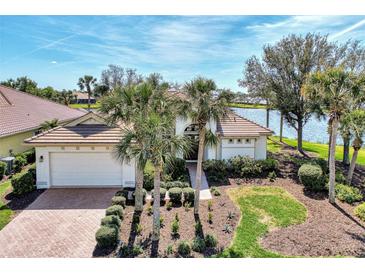 Single-story home with tile roof, palm trees, and a brick driveway, offering curb appeal at 4233 Grosse Pointe Dr, Port Charlotte, FL 33953