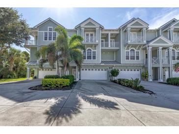 Three-story townhouses with attached garages, lush landscaping, and a paved driveway at 10360 Longshore Rd # 66, Placida, FL 33946