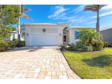Single-story home with a paver driveway and landscaped front yard at 10479 Coquina Ct, Placida, FL 33946