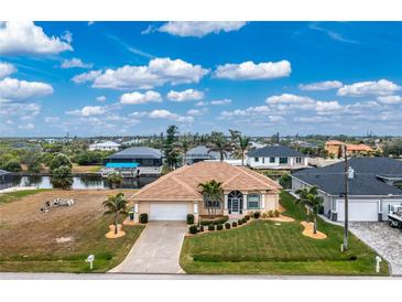 Aerial view of a single-Gathering home with a landscaped yard and canal access at 15626 Meacham Cir, Port Charlotte, FL 33981