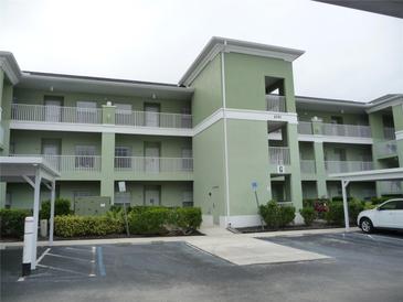 Green two-story condo building with parking and landscaping at 2121 Heron Lake Dr # 301, Punta Gorda, FL 33983