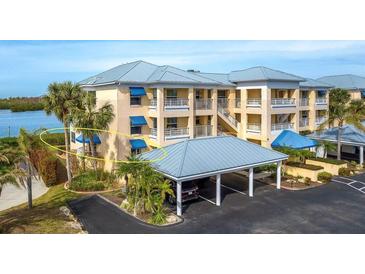Attractive waterfront condo building with parking and tropical landscaping at 2424 Placida Rd # C101, Englewood, FL 34224
