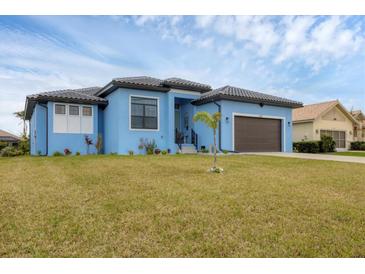 Beautiful light blue house with a brown garage door and nicely landscaped lawn at 4220 Cape Haze Dr, Placida, FL 33946