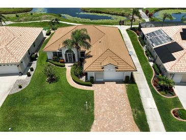 Aerial view of single-Gathering home with tile roof, landscaping, and paver driveway at 8596 Lakeside Dr, Englewood, FL 34224