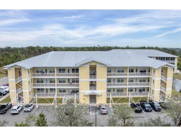 Exterior of two-story building with parking and landscaping at 102 Natures Way # 2305, Rotonda West, FL 33947