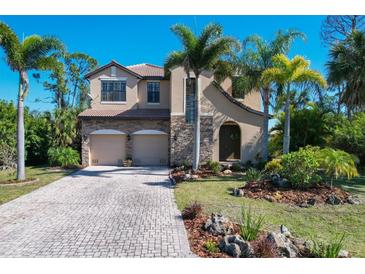 Two-story house with stone accents and palm trees at 117 Cable Dr, Rotonda West, FL 33947