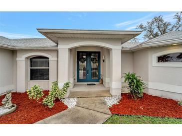 Inviting front entrance with double doors and landscaped walkway at 13235 Essman Ave, Port Charlotte, FL 33953