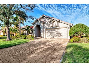 Single-story home with a tile roof, large driveway, and lush landscaping at 14394 Silver Lakes Cir, Port Charlotte, FL 33953