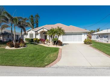 Single-story home with landscaped yard, driveway, and two-car garage at 276 Long Meadow Ln, Rotonda West, FL 33947