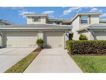 Two-story home with neutral paint, tile roof, two-car garage, and manicured landscaping at 3323 Grand Vista Ct # 201, Port Charlotte, FL 33953