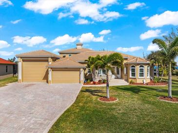 Beautiful waterfront home with a large yard, attached garage, and palm trees at 10544 Poughkeepsie Cir, Port Charlotte, FL 33981