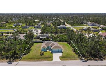 Spacious single-Gathering home with a well-manicured lawn, framed by lush greenery in a serene neighborhood at 12075 Duval Blvd, Port Charlotte, FL 33981