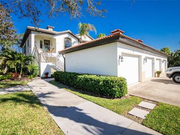 White building with attached garage and lush landscaping at 129 Preserve Pl # A, Nokomis, FL 34275