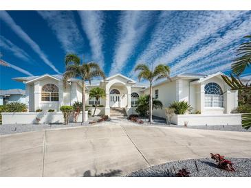 White two-story home with palm trees and circular driveway at 210 Capstan Dr, Placida, FL 33946