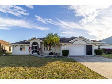 Single-story home with a two-car garage and landscaped lawn at 23111 Mineral Ave, Port Charlotte, FL 33954