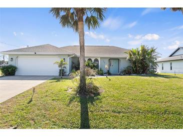 Charming single-story home with a lush lawn and mature palm tree in a desirable neighborhood at 254 Mark Twain Ln, Rotonda West, FL 33947