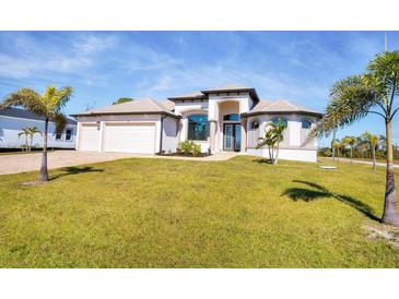 Single-story home with a large yard, two-car garage, and attractive landscaping at 48 Master Dr, Placida, FL 33946