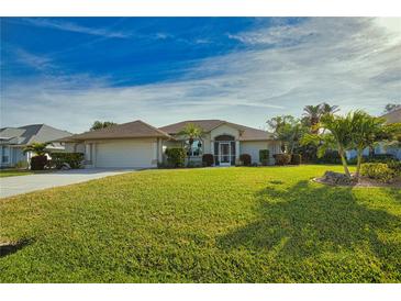 Single-story home with a well-manicured lawn and attached garage at 8 Sportsman Rd, Rotonda West, FL 33947