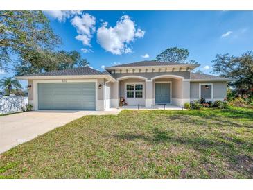 Newly constructed one-story home with attached garage and landscaped yard at 1312 Wasilla St, North Port, FL 34291